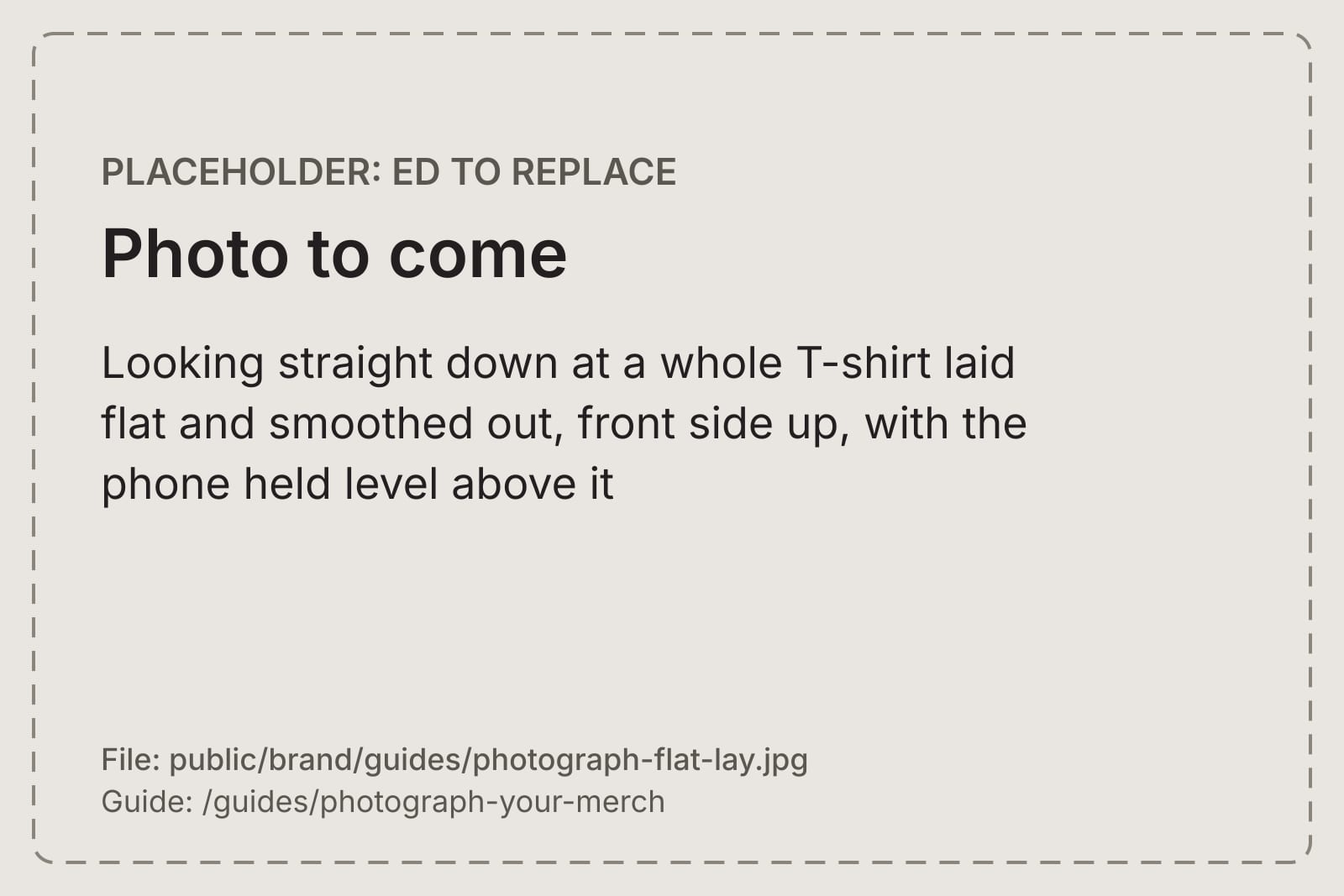 Looking straight down at a whole T-shirt laid flat and smoothed out, front side up, with the phone held level above it