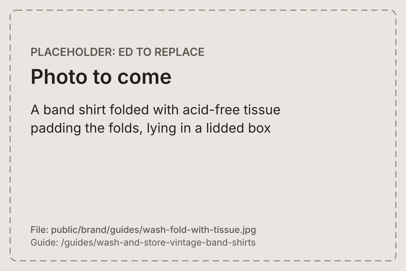 A band shirt folded with acid-free tissue padding the folds, lying in a lidded box