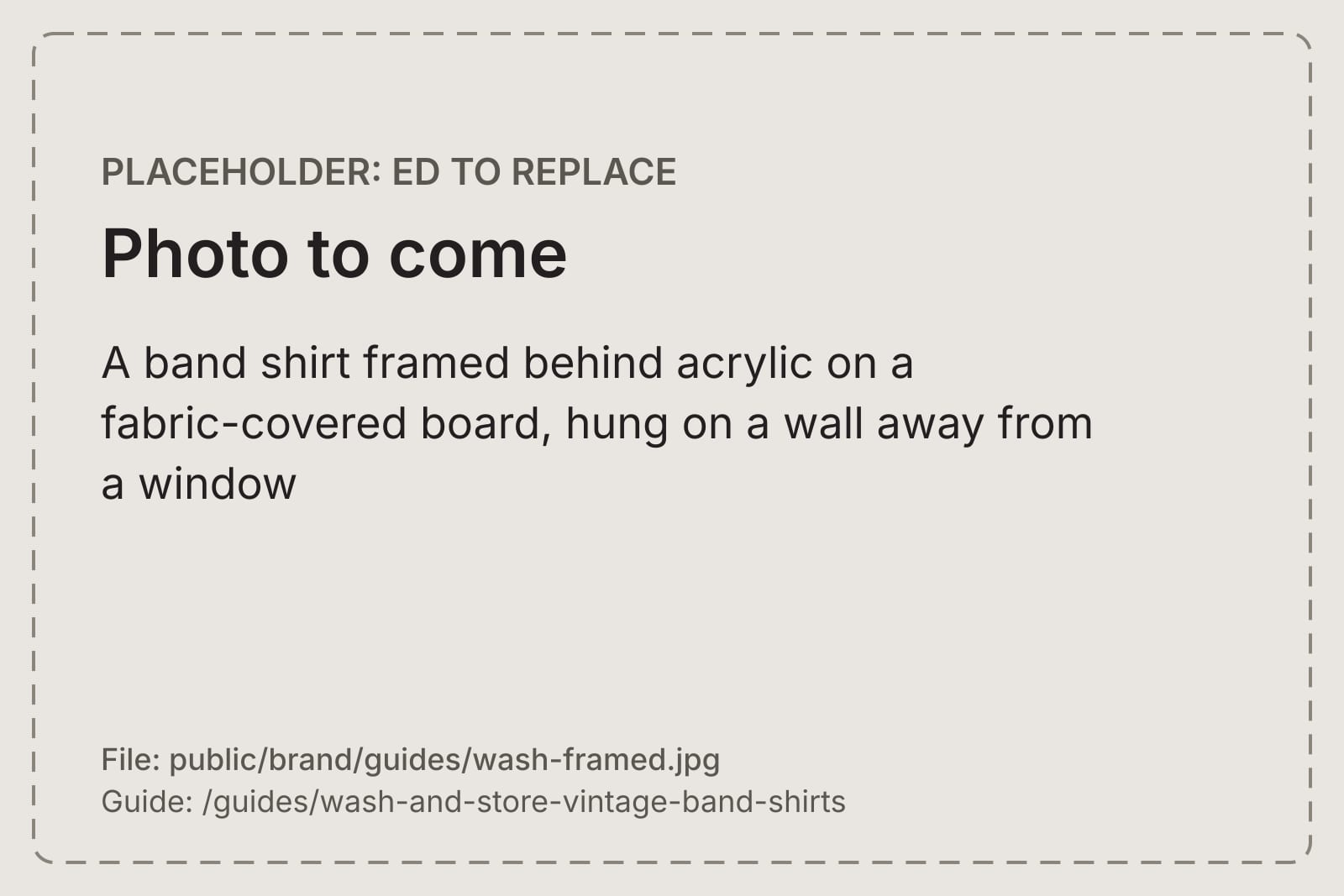 A band shirt framed behind acrylic on a fabric-covered board, hung on a wall away from a window
